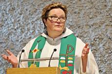 Pfarrerin Nicole Otte-Kempf im weißen Talar mit grüner Stola